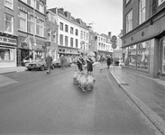 880567 Afbeelding van het drijven van een koppel ganzen door enkele Drentse ganzenhoedsters door de Voorstraat te ...